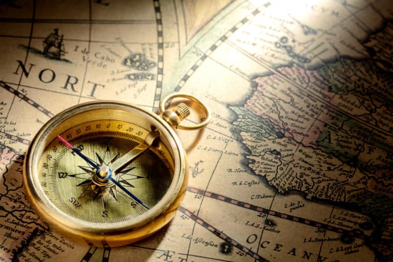 Antique compass on ancient map